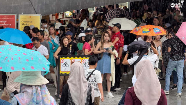 【直播】长时间撑伞占好位 大雨浇不走滨海湾跨年人潮