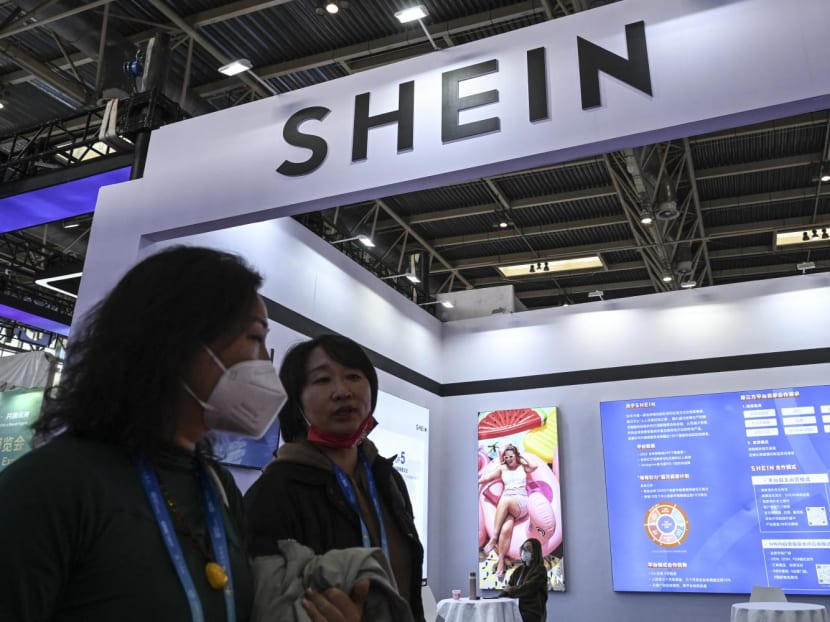 People walk past the booth of fast fashion e-commerce company Shein during the China International Supply Chain Expo in Beijing on Dec 1, 2023.