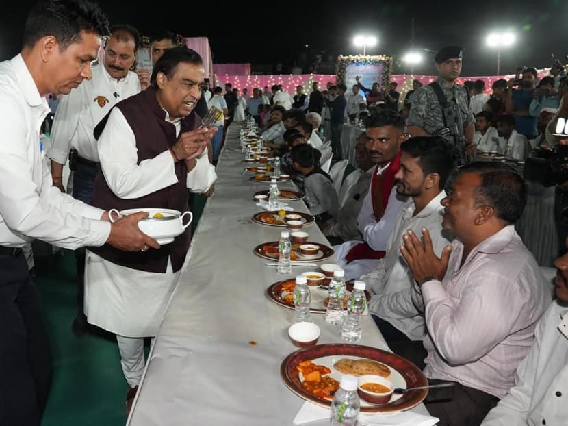 This handout photograph taken and released by Reliance on Feb 28, 2024, shows Mr Mukesh Ambani (in brown), chairman at Reliance Industries attending to guests during Anna Seva (community food service) to seek blessings from various community members for the pre-wedding celebration of his son Anant Ambani and Ms Radhika Merchant in Jamnagar, India. This handout photograph taken and released by Reliance on Feb 28, 2024, shows Mr Mukesh Ambani (in brown), chairman at Reliance Industries attending to guests during Anna Seva (community food service) to seek blessings from various community members for the pre-wedding celebration of his son Anant Ambani and Ms Radhika Merchant in Jamnagar, India.