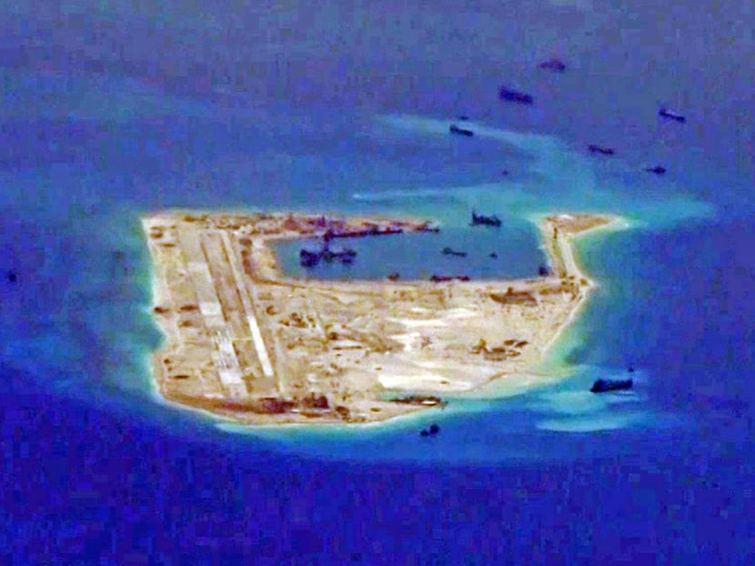 Chinese dredging vessels are purportedly seen in the waters around Fiery Cross Reef in May. Once the airstrip on the reef is operational, China could use it as an alternative runway for carrier-based aircraft. Reuters
