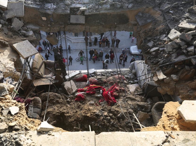 Palestinians gather at the site of an Israeli strike, amid the ongoing conflict between Israel and the Palestinian Islamist group Hamas, in Rafah in the southern Gaza Strip Jan 10, 2024.