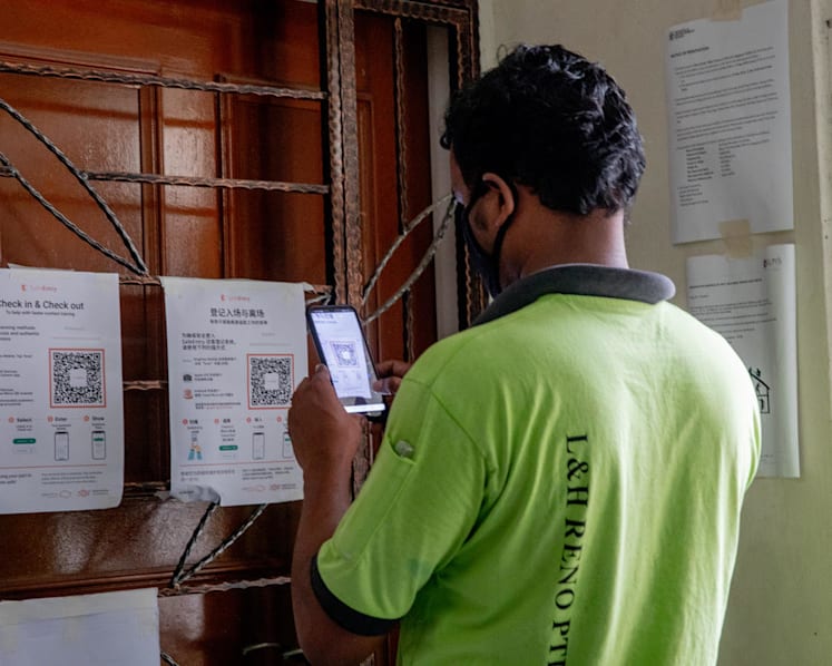 Migrant workers learn to use apps for contact tracing, health reporting before they can resume work