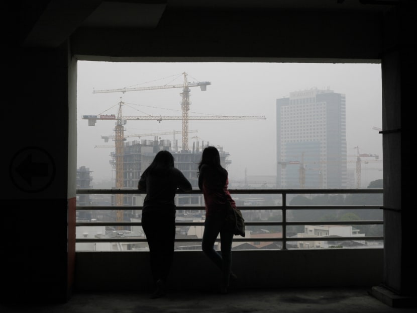 Indonesian women are silhouetted against the city skyline which is shrouded by the haze from forest fires, in Medan, North Sumatra, Indonesia. Photo: AP Indonesian women are silhouetted against the city skyline which is shrouded by the haze from forest fires, in Medan, North Sumatra, Indonesia. Photo: AP