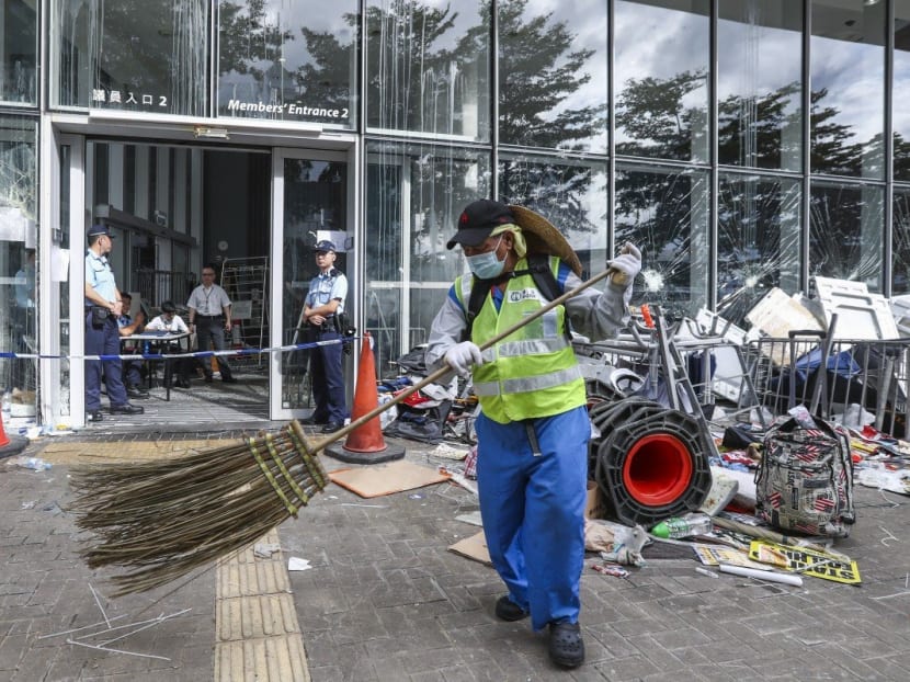 A worker begins the process of cleaning up after the Legislative Council complex was vandalised during an anti-government protest on July 1.