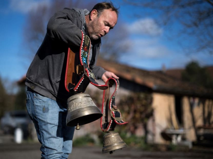 Farmer Rolf Rohrbach blows to remove dust of cow bells used during transhumance in the village of Aarwangen, central Switzerland, on Nov 29, 2023.