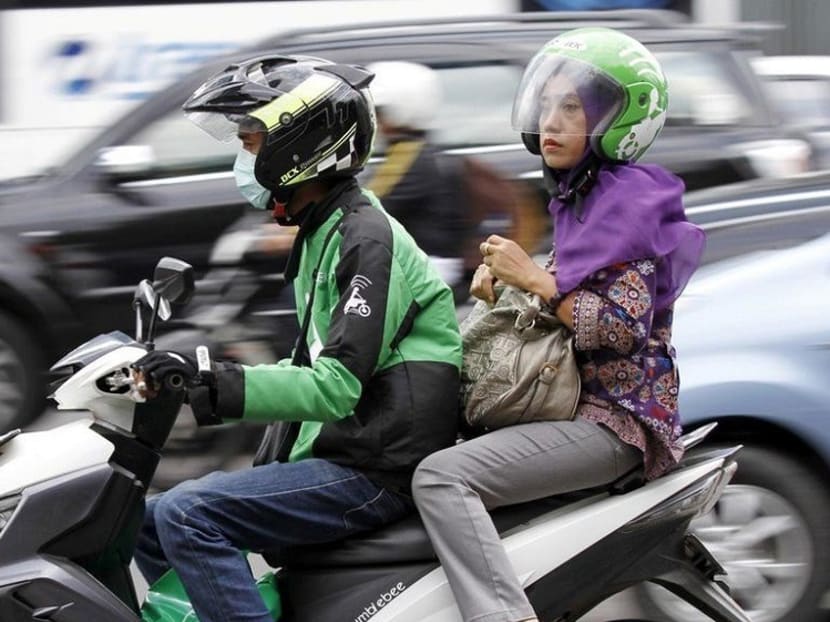 A woman uses the Go-Jek service in Jakarta. A woman uses the Go-Jek service in Jakarta.