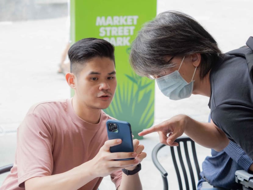 Mr Calvin Ong (left), a volunteer from 1ThirdMedia Movement, collecting postal votes from Malaysians based in Singapore.
