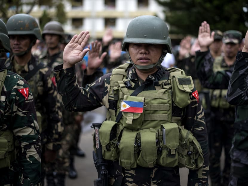 A soldier takes an oath during a flag raising ceremony at the Lanao Del Sur provincial capital of Marawi on the southern island of Mindanao on June 12, 2017. Embattled Philippine troops struggling to force out Islamist militants from a southern city raised the national flag for Independence Day on June 12, in a tearful ceremony dedicated to the scores killed during the conflict.  Photo: AFP