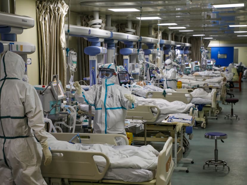 Medical workers in protective suits attend to novel coronavirus patients at the intensive care unit of a designated hospital in Wuhan, Hubei province, China, Feb 6, 2020.