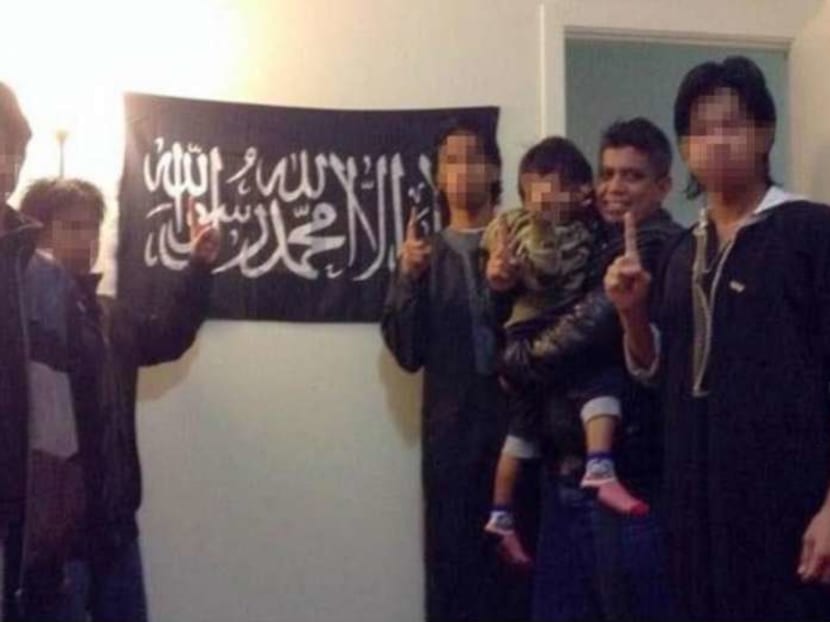 A photo Zulfikar Shariff posted on his Facebook page of himself with his children in front of a flag used by jihadi terror groups.