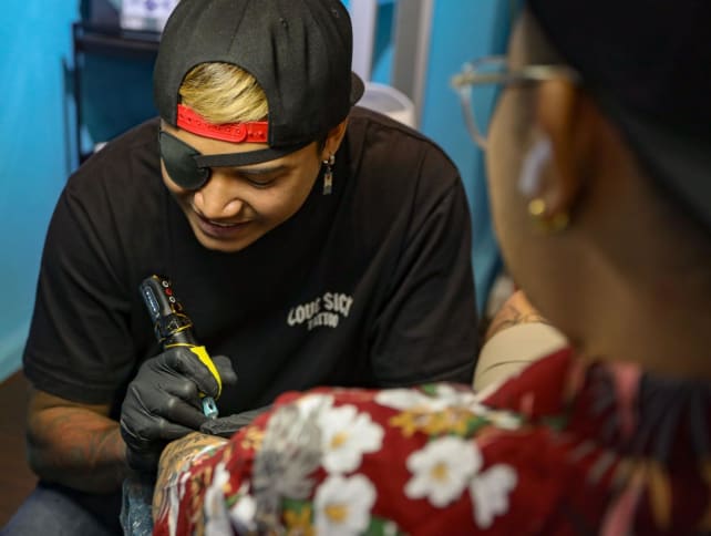 Tattoo artist Mohamed Tirana Mohamed Sufian working on a tattoo in his studio at Parklane Shopping Mall on Sept 16, 2024. 