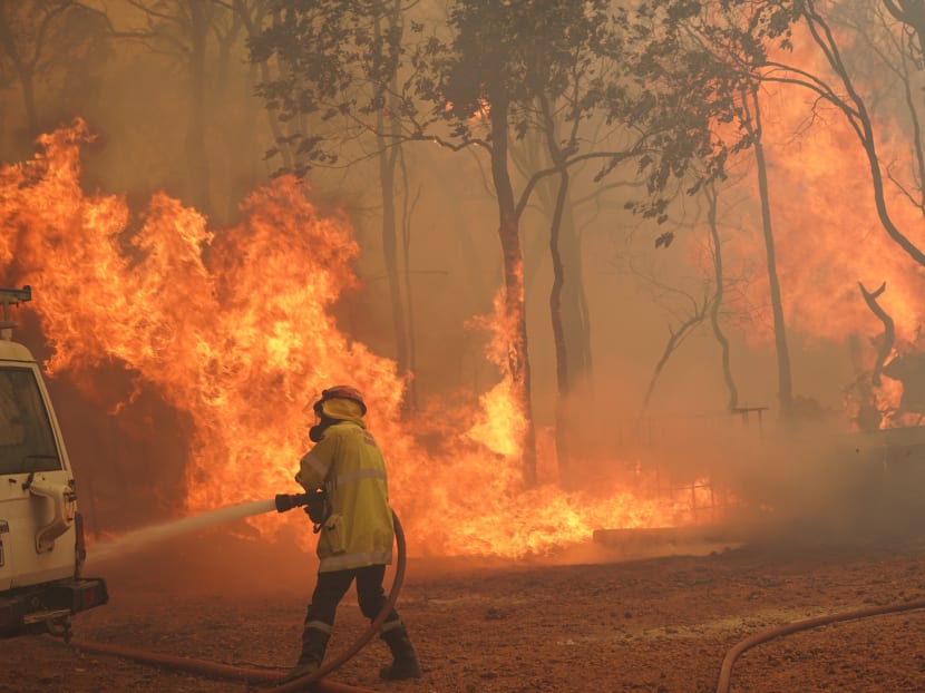 This handout photo taken on February 2, 2021 and released by West Australia's Department of Fire and Emergency Services (DFES) shows a firefighter fighting a fire outside Wooroloo, near Australia's fourth-biggest city Perth.