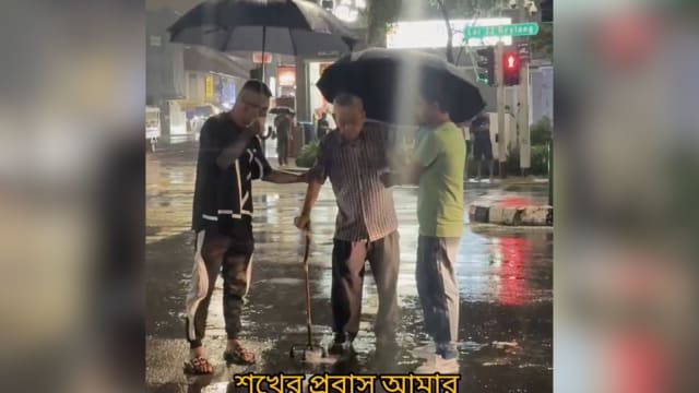 老翁吃力拄拐杖冒雨过马路 两男撑伞扶他过去