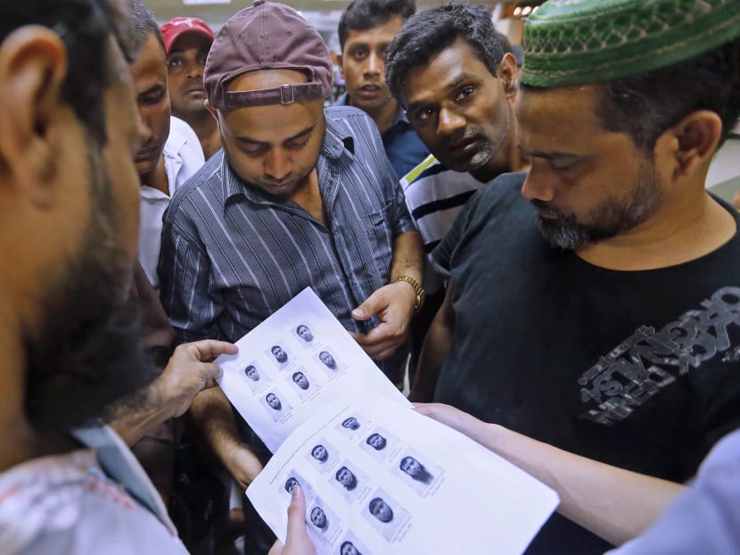 Bangladeshis in Little India looking at photos of the 27 Bangladeshi construction workers who were arrested here under the ISA. Bangladeshis TODAY spoke to condemned the actions of those arrested, with some saying they hope the incident would not stain the image of the Bangladeshi community here. Photo: Ernest Chua/TODAY