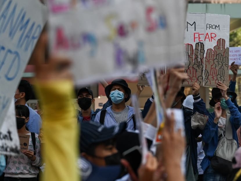 Protesters hold up placards during a demonstration against the Feb 1 military coup in Yangon on Feb 10, 2021.