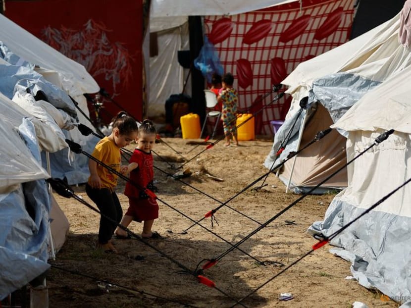 Displaced Palestinian kids, who fled their houses amid Israeli strikes, take shelter in a tent camp at a United Nations-run centre, after Israel's call for more than 1 million civilians in northern Gaza to move south, in Khan Younis in the southern Gaza Strip, October 24, 2023. REUTERS/Ibraheem Abu Mustafa