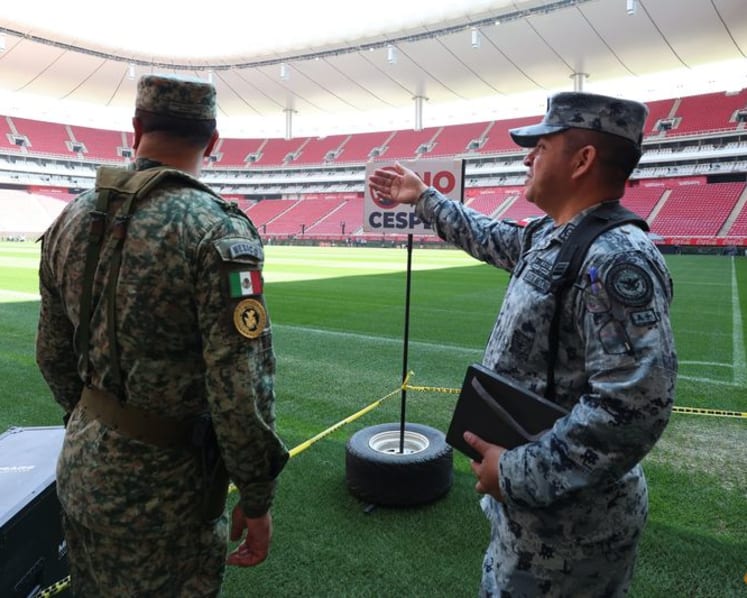 Mexican fans enjoy a brief respite from violence as they gaze at World Cup trophy