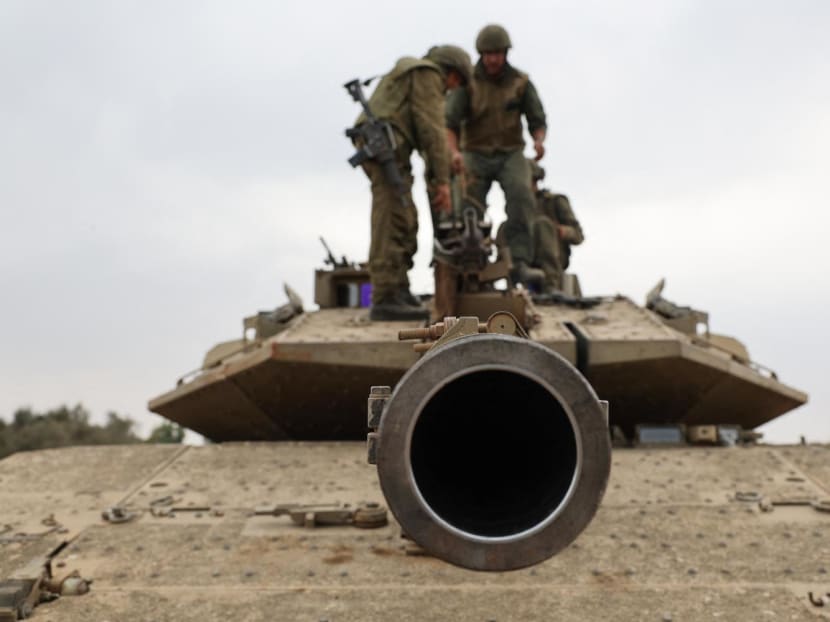 Israeli army soldiers are positioned with their Merkava tanks near the border with the Gaza Strip in southern Israel on Oct 9, 2023. Israel relentlessly pounded the Gaza Strip as fighting raged with Hamas around the Gaza Strip and the death toll from the war against the Palestinian militants surged above 1,100.