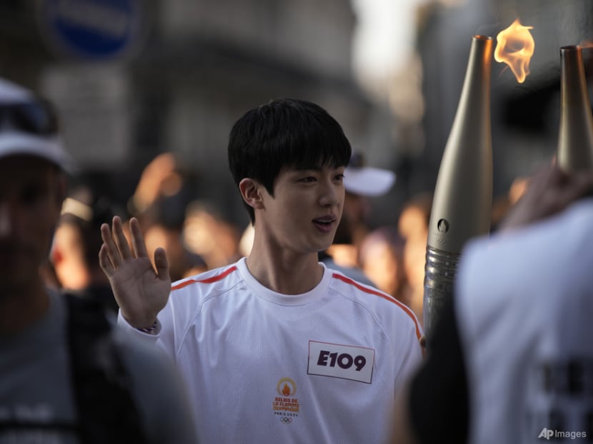BTS member Jin carries Olympic torch in Paris near Louvre Museum BTS member Jin carries Olympic torch in Paris near Louvre Museum