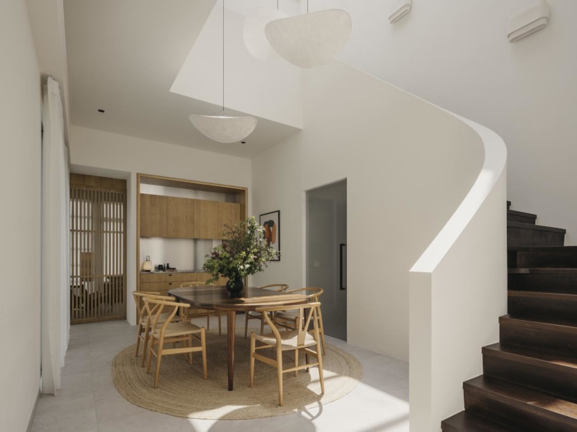 A sweeping concrete staircase takes centre stage in this penthouse in Singapore