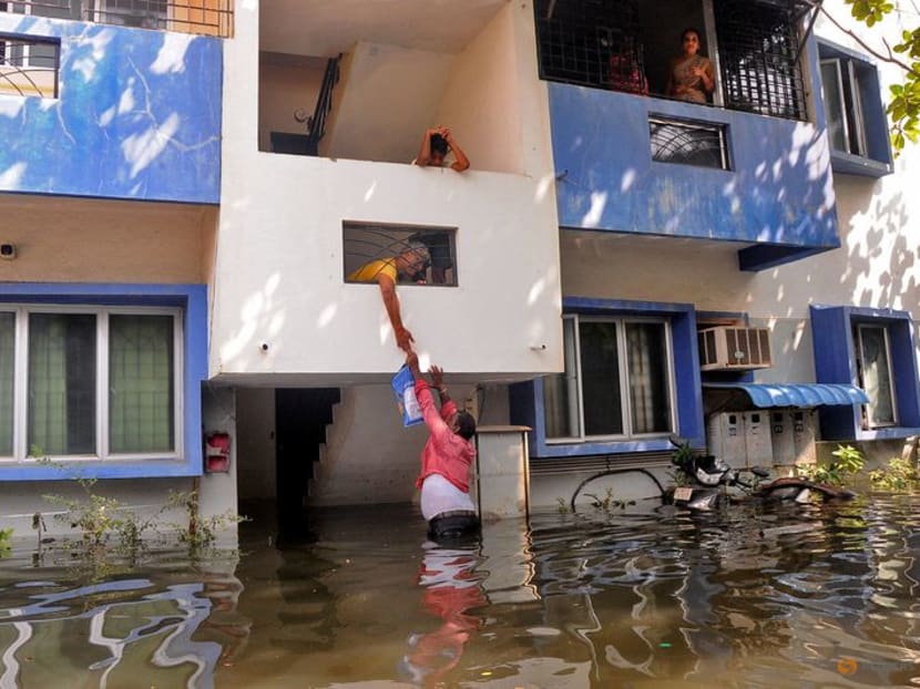 FILE PHOTO: A volunteer offers food to a resident after his house got partially submerged following heavy rains due to Cyclone Michaung, in Chennai, India, December 6, 2023. REUTERS/Stringer/File photo