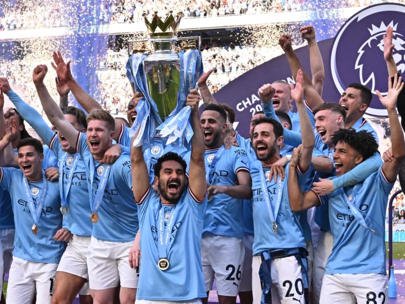 Manchester City's German midfielder Ilkay Gundogan lifts the trophy as Manchester City players celebrate winning the title at the presentation ceremony following the English Premier League football match between Manchester City and Chelsea at the Etihad Stadium in Manchester, Northwest England, on May 21, 2023. Manchester City's German midfielder Ilkay Gundogan lifts the trophy as Manchester City players celebrate winning the title at the presentation ceremony following the English Premier League football match between Manchester City and Chelsea at the Etihad Stadium in Manchester, Northwest England, on May 21, 2023.