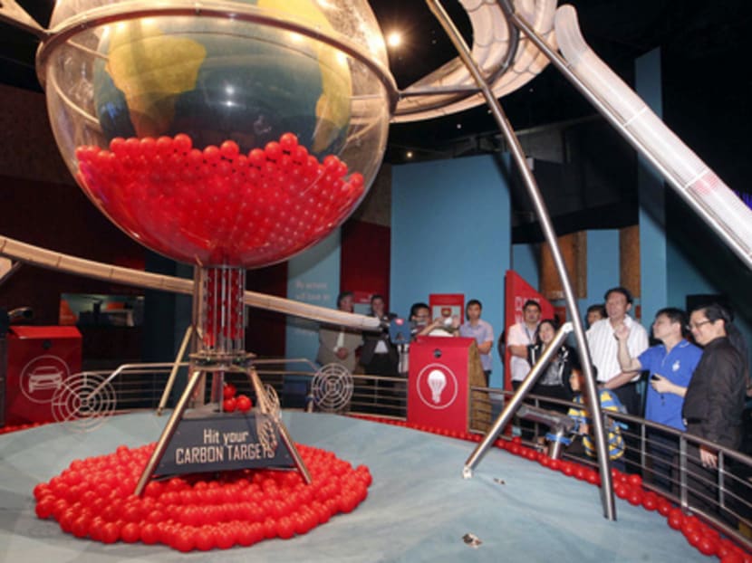 Deputy Prime Minister Teo Chee Hean (third from right) looking at the Climate Machine, which represents carbon dioxide entering and leaving the Earth’s atmosphere, during a tour of the Climate Change Climate Challenge Exhibition at 
the Science 
Centre yesterday. 
Photo: Ooi Boon Keong