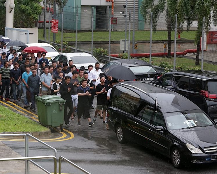 Family, friends brave rain to bid final farewell to murdered businessman