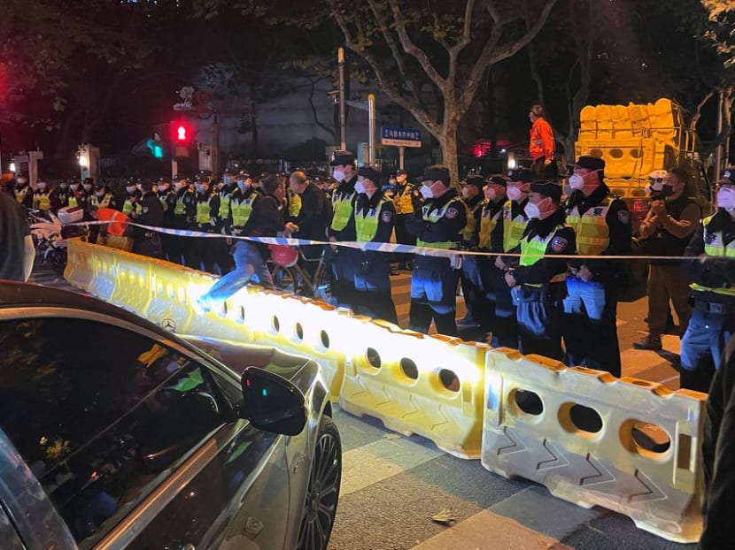 Police officers stand behind barricades and cordon at the site where a protest against Covid-19 curbs took place the night before, following the deadly Urumqi fire, in Shanghai, China Nov 27, 2022. 
