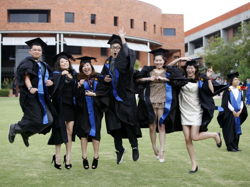 Chinese students dressed in academic gowns pose during a graduation photo shoot at Curtin University in Bentley, Perth, Western Australia, in 2012.