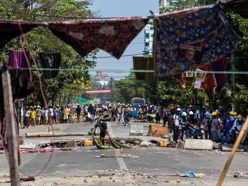 A protester sets up a barricade further down from another barricade made across a road with longyi, a traditional clothing widely worn in Myanmar, during a demonstration against the military coup in Yangon on March 4, 2021. A protester sets up a barricade further down from another barricade made across a road with longyi, a traditional clothing widely worn in Myanmar, during a demonstration against the military coup in Yangon on March 4, 2021.