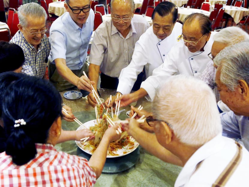 A plate of yusheng containing abalone slices, instead of raw fish, being tossed at Red Star restaurant in Chin Swee Road. Photo: Raj Nadarajan/TODAY
