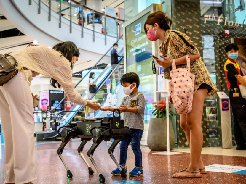 A 5G K9 robot distributes hand sanitiser to visitors in a shopping mall in Bangkok on June 4, 2020, as sectors of the economy reopen following restrictions to halt the spread of Covid-19.