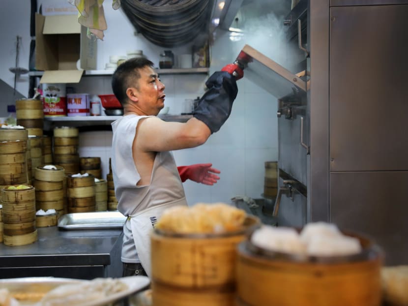 This picture taken on November 20, 2015, shows a cook working the steamer in the kitching of the Sun Hing dim sum restaurant in the Kennedy Town district of Hong Kong. With much of the city's famous "dim sum" snacks now factory-made, a core of dedicated chefs are determined to prevent the handmade tradition from dying out. Photo: AFP