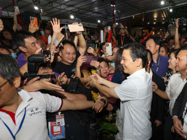 A jubilant crowd of residents greeting and shaking hands with Prime Minister Lawrence Wong at a viewing party in Yew Tee on May 15, 2024. 