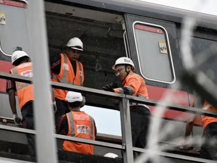 A repair crew is seen on Sept 26, 2024, working on a faulty MRT train along Commonwealth Ave West. 