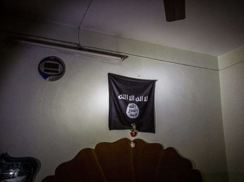 An Islamic State flag hangs above a bed in a house once used by militants in west Mosul, Iraq.