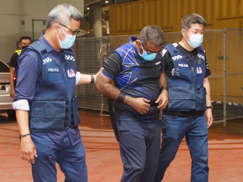 A 50-year-old man (centre) was handed over from the Royal Malaysia Police to the Singapore Police Force on Nov 16, 2022. 