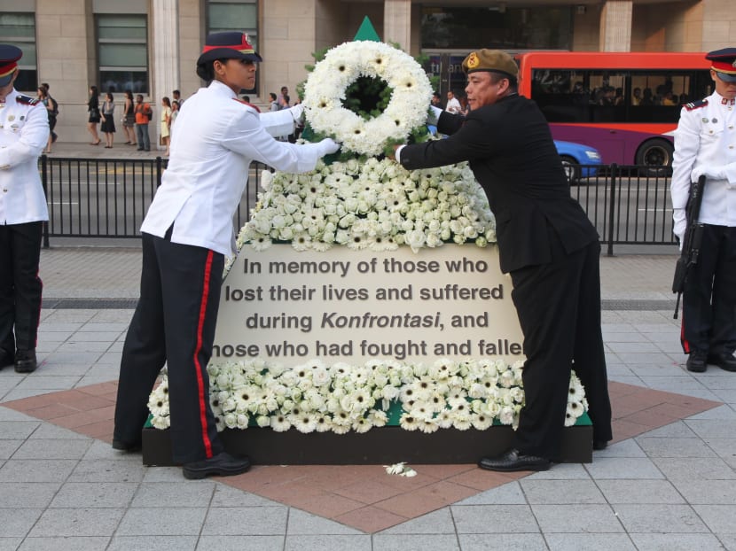 National Cadet Corps Honour Guard Siti Sabrina and BG (NS) Winston Koh laying a wreath during the 49th anniversary memorial service organised by the SAF Veterans' League for vicitims who perished in the bombing of McDonald House during Konfrontasi,  March 10 2014. Photo: Don Wong.