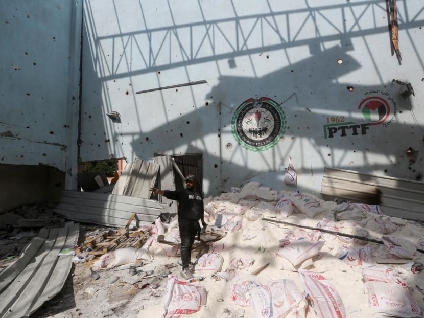 A Palestinian inspects the site of an Israeli strike on an aid warehouse, amid the ongoing conflict between Israel and Hamas, in Al-Nuseirat refugee camp in the central Gaza Strip on March 14, 2024.
