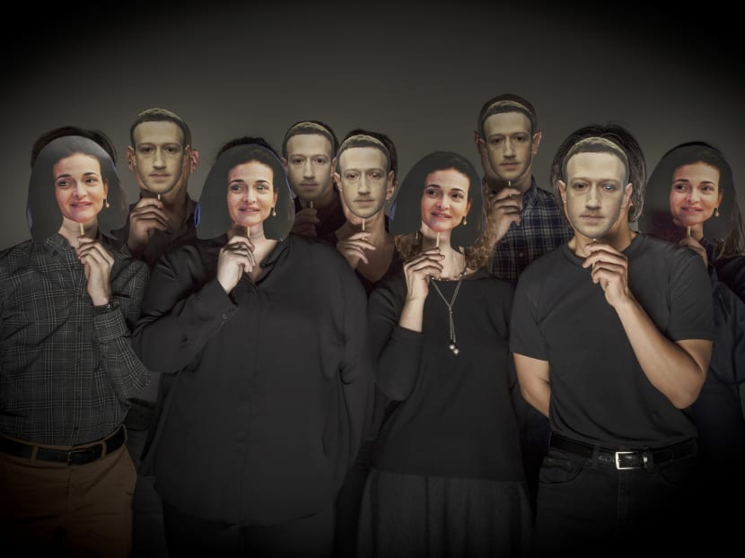 Models in a photo studio pose with masks depicting Facebook executives Mark Zuckerberg and Cheryl Sandberg in New York.