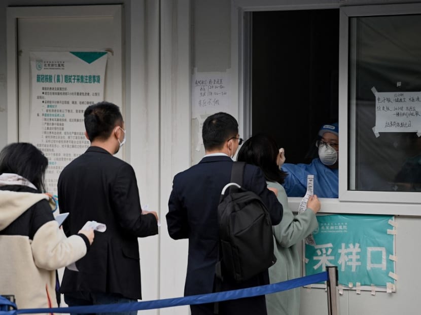 A health worker takes a swab sample from a woman to be tested for Covid-19 coronavirus in Beijing on Oct 28, 2021.