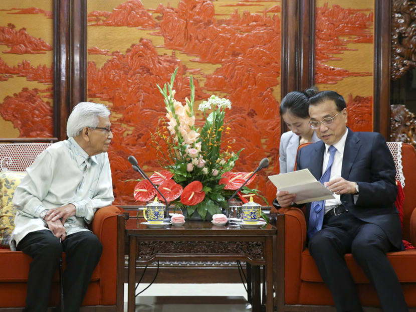Chinese Premier Li Keqiang looks at a letter given by Malaysia's Prime Minister Tun Mahathir Mohamad during a meeting with Mr Daim Zainuddin in Beijing.
