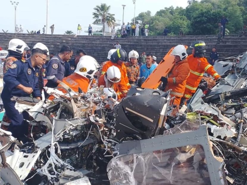 Rescuers inspecting the debris of the fatal Perak helicopter crash. Rescuers inspecting the debris of the fatal Perak helicopter crash.