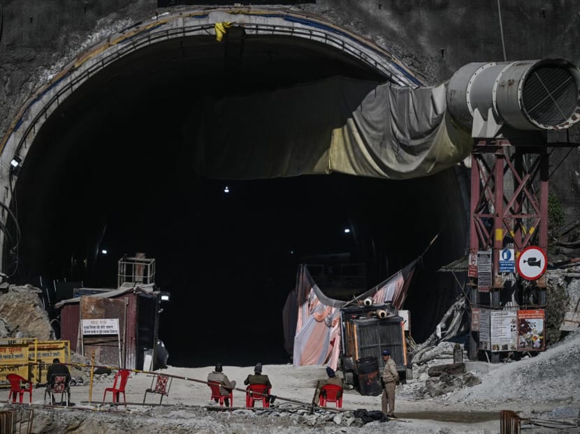 Police sit at the entrance of the under construction Silkyara tunnel in the Uttarkashi district of India's Uttarakhand state on Nov 29, 2023, a day after rescue teams safely brought out all the workers from the collapsed Himalayan road tunnel.
