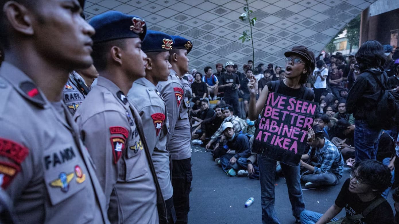 手持标语牌的示威者向警员大声喊话。（图：路透社/Willy Kurniawan）