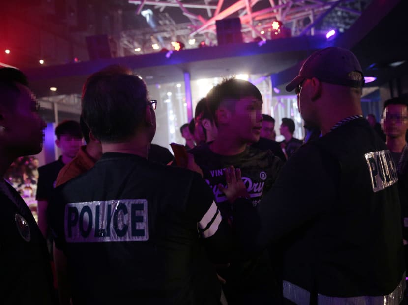 A man argues with police officers as he is arrested during an enforcement operation in a nightclub at St James Powerstation on 3 Dec, 2017. This photo has been digitally altered to protect identities of police officers and/or suspects. Photo: Jason Quah/TODAY