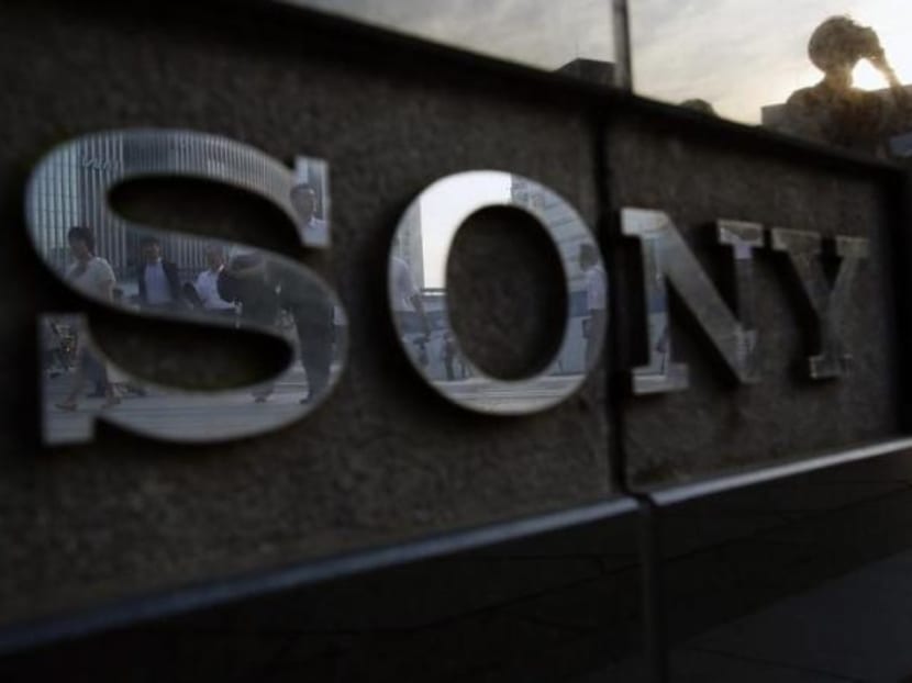 Pedestrians are reflected in a logo of Sony Corp outside its showroom in Tokyo, July 16, 2014. Photo: Reuters