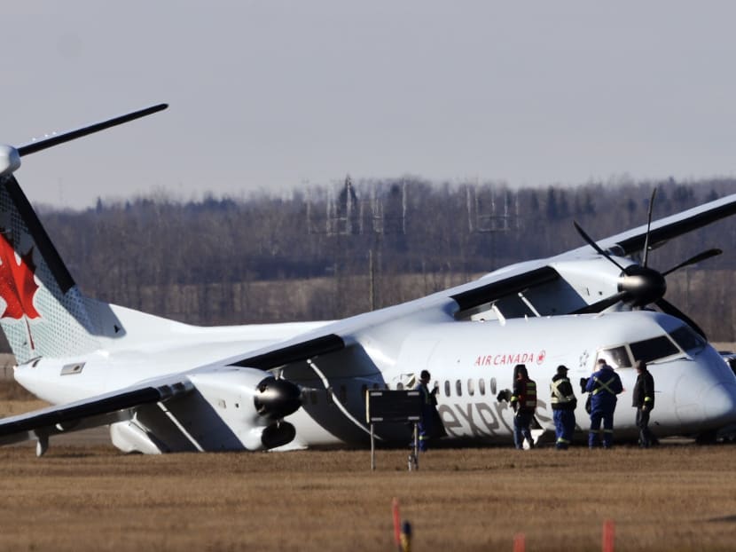 Investigators comb the area around an Air Canada plane on the tarmac of the Edmonton International Airport. Photo: Reuters