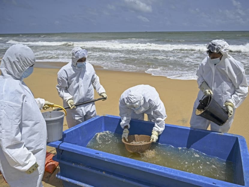 Members of the Sri Lankan Navy work to remove debris washed ashore from the Singapore-registered container ship MV X-Press Pearl, which is sinking after burning for almost three weeks in the sea off Colombo Harbour, in Colombo on June 18, 2021. Members of the Sri Lankan Navy work to remove debris washed ashore from the Singapore-registered container ship MV X-Press Pearl, which is sinking after burning for almost three weeks in the sea off Colombo Harbour, in Colombo on June 18, 2021.